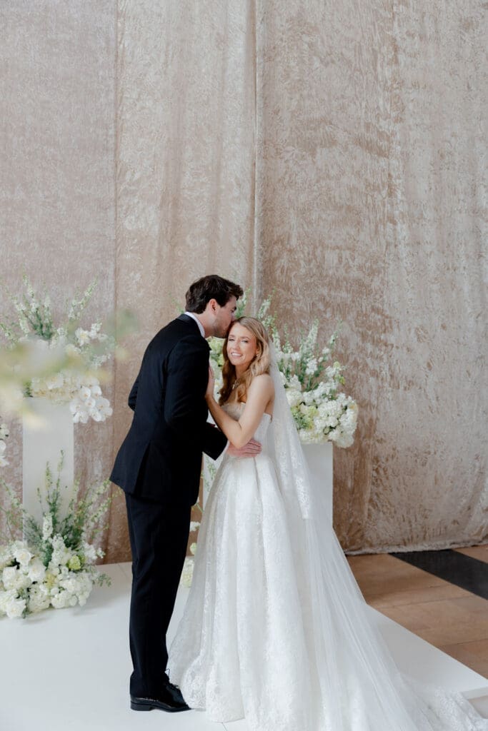 groom kissing the bride on the forehead